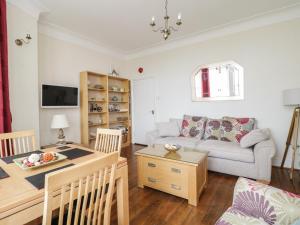 uma sala de estar com um sofá e uma mesa em The Nook em Tywyn