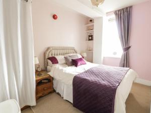 um quarto com uma cama grande e uma janela em The Nook em Tywyn