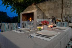 a table with a white table cloth and wine glasses at Villa Rustica in Neum