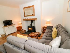 a living room with a couch and a fireplace at Curlew Cottage, 2 Fenkle Street in Berwick-Upon-Tweed