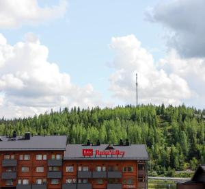 um edifício com um sinal vermelho em cima em Ski-Inn RukaValley em Ruka