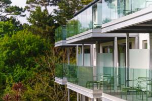 a glass facade of a building with green chairs at Hotel Meudon in Falmouth