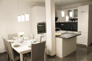Il comprend une cuisine et une salle à manger avec une table et des chaises blanches. dans l'établissement Sunny Hill, à Ston