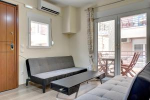 ein Wohnzimmer mit einem Sofa und einem Tisch in der Unterkunft Achilleas Apartments in Kalivia Poligirou