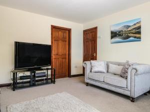 a living room with a couch and a flat screen tv at Grimbles Cottage in Ulverston