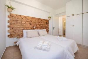 una camera da letto con un grande letto bianco con asciugamani di Alta Vista Luxury House a Kardámaina