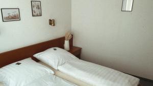 - un petit lit avec deux oreillers dans l'établissement Hotel Zur Sonne, à Kirchhain