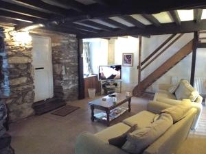 a living room with two couches and a tv at Poet's Cottage in Trefriw