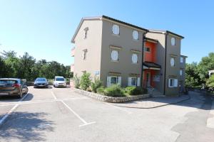 un edificio con auto parcheggiate in un parcheggio di Apartment Boltar a Šilo