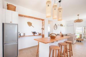 una cucina con frigorifero e tavolo con sgabelli di Alta Vista Luxury House a Kardámaina