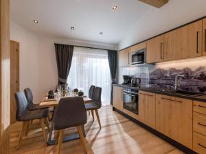 kuchnia ze stołem i krzesłami oraz jadalnia w obiekcie Dorfkaiser Appartements w mieście Going
