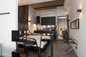 a kitchen with black and white walls and a bar with stools at Midtown Hotel Rotterdam in Rotterdam