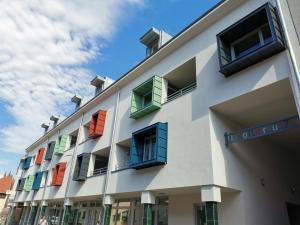 a building with colorful windows on the side of it at Antracit Apartman in Pécs