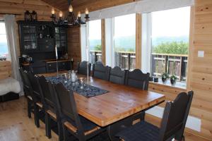 comedor con mesa de madera y sillas en Storemyr by Norgesbooking - cabin with amazing view, en Myro