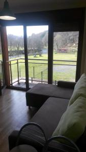 a living room with a large window with a view of a field at En el Sella in Cangas de Onís