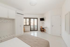 Biały salon z białymi szafkami i telewizorem w obiekcie B&B Castello Otranto w mieście Otranto