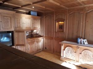 a large kitchen with wooden cabinets and a counter at Valbella Appartements in Partenen