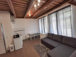 sala de estar con sofá negro y mesa en Greenfield Apartman, en Kisoroszi