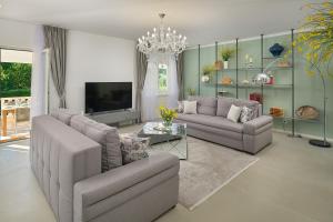 een woonkamer met twee banken en een tv bij Holiday Home Plasa in Žrnovnica