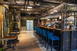 un bar avec des chaises bleues dans un restaurant dans l'établissement B&B HOTEL Clermont-Ferrand A71-A75 La Méridienne, à Clermont-Ferrand