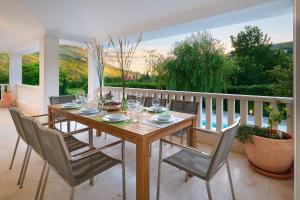 een houten tafel en stoelen op een balkon bij Holiday Home Plasa in Žrnovnica