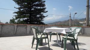 a table and chairs on a patio with a tree at Estía Holidays Apartments - Taormina in Taormina