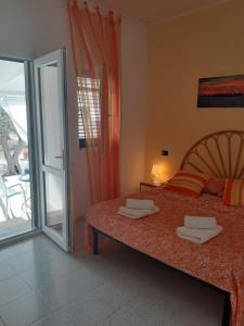 sypialnia z łóżkiem i przesuwnymi szklanymi drzwiami w obiekcie Casa Vacanza Fiorella w mieście Torre dell'Orso