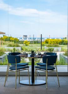 a table with three chairs and a table with a view at HVD Reina del Mar - Premium Spa Service & Free Parking in Obzor