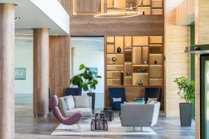 a lobby with two chairs and a couch at HVD Reina del Mar - Premium Spa Service & Free Parking in Obzor