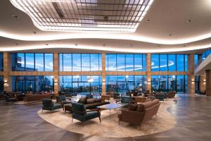 a lobby with couches and chairs and large windows at HVD Reina del Mar - Premium Spa Service & Free Parking in Obzor