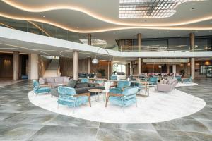a lobby with chairs and tables in a building at HVD Reina del Mar - Premium Spa Service & Free Parking in Obzor