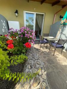un patio con fiori, tavolo e sedie di Villa Anna Sorgeto a Ischia Altre 10 foto