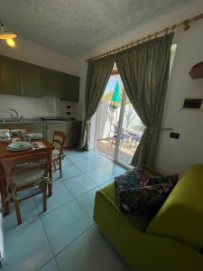 un soggiorno con un divano verde e un tavolo di Villa Anna Sorgeto a Ischia