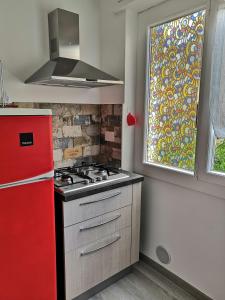 eine Küche mit einem roten Herd und einem Fenster in der Unterkunft CasAgnese in Sanremo