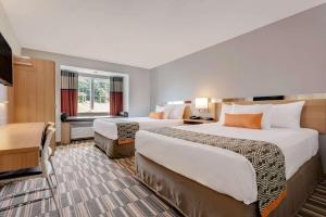 Microtel Inn & Suites by Wyndham Clarion tesisinde bir odada yatak veya yataklar