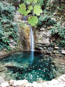 a pool of water in front of a waterfall at Hotel Pineta in Cagli