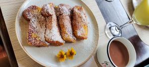 a plate of french toast on a table with a cup of coffee at Finca Cafetera Los Ángeles in Líbano