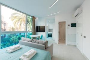 ein Wohnzimmer mit Couch und großem Fenster in der Unterkunft Edison Building By CanariasGetaway in Guanarteme
