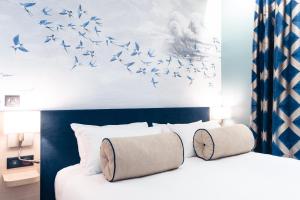 a bedroom with a bed with birds flying in the air at Hôtel Bleu de Grenelle in Paris