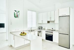 a white kitchen with a bowl of fruit on a counter at VILA AMALIE - 3BDR+3 BATH in Amarilla Golf in San Miguel de Abona