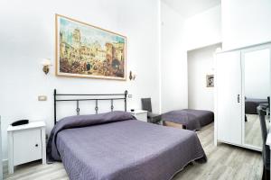 a bedroom with a bed and a painting on the wall at Hotel Fontana in Amalfi