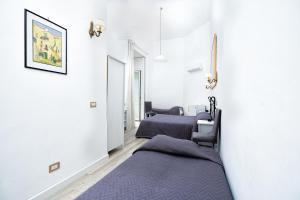 a row of beds in a room with white walls at Hotel Fontana in Amalfi