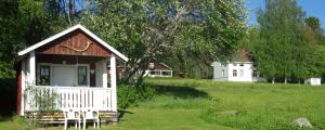 ein kleines Haus inmitten eines Feldes in der Unterkunft Stugor Storsjöns strand in Hackås