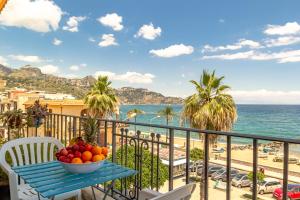 eine Schale mit Obst auf einem Tisch auf einem Balkon mit Blick auf den Strand in der Unterkunft La Casa di Elvira in Giardini-Naxos