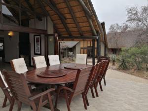 einen Holztisch und Stühle auf einer Terrasse in der Unterkunft Morokolo Safari Lodge Self-catering in Pilanesberg