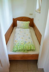 - un lit avec un cadre en bois et un oreiller dans l'établissement Ferienwohnung Gassoid, à Fieberbrunn