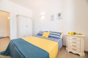 a bedroom with a bed with a blue and yellow blanket at Villa Ma.rie in Torre Suda