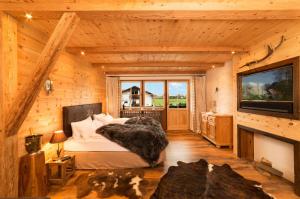a bedroom with a bed and a television in a log cabin at Chalet Harmonie in Inzell