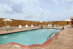 a large swimming pool with chairs and umbrellas at Holiday Inn Hotels Batesville by IHG in Batesville