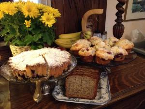 a table topped with cakes and pastries and flowers at Holiday Lodge Bed and Breakfast in Banff